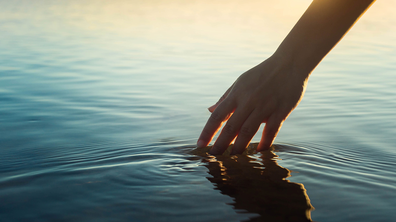 TouchingWater A woman gently touching water in reflection